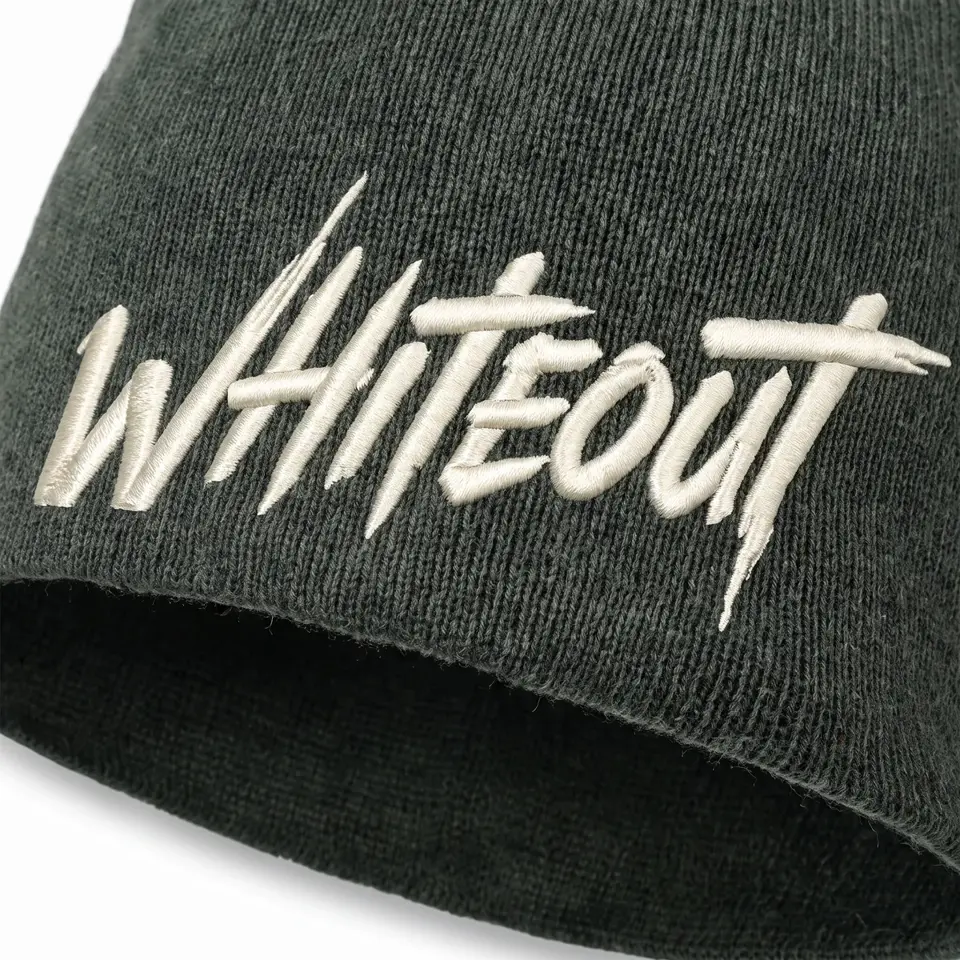 Ascent Skull Cap beanie in Dark Green: close-up of the cuff embroidery