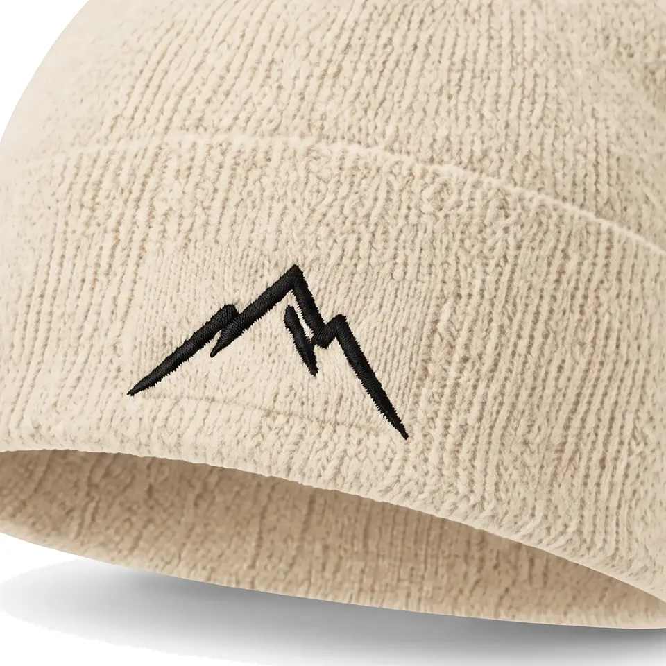 Atelier beanie in Cream: close-up of the cuff embroidery