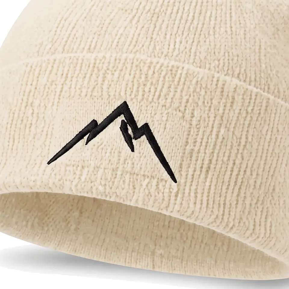 Col Rib beanie in Cream: close-up of the cuff embroidery