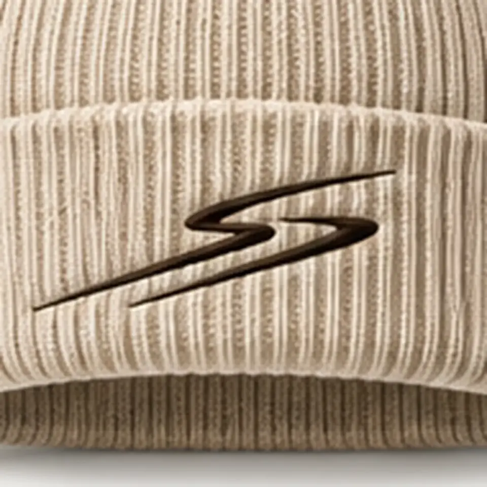 Drift beanie in Beige: close-up of the cuff embroidery