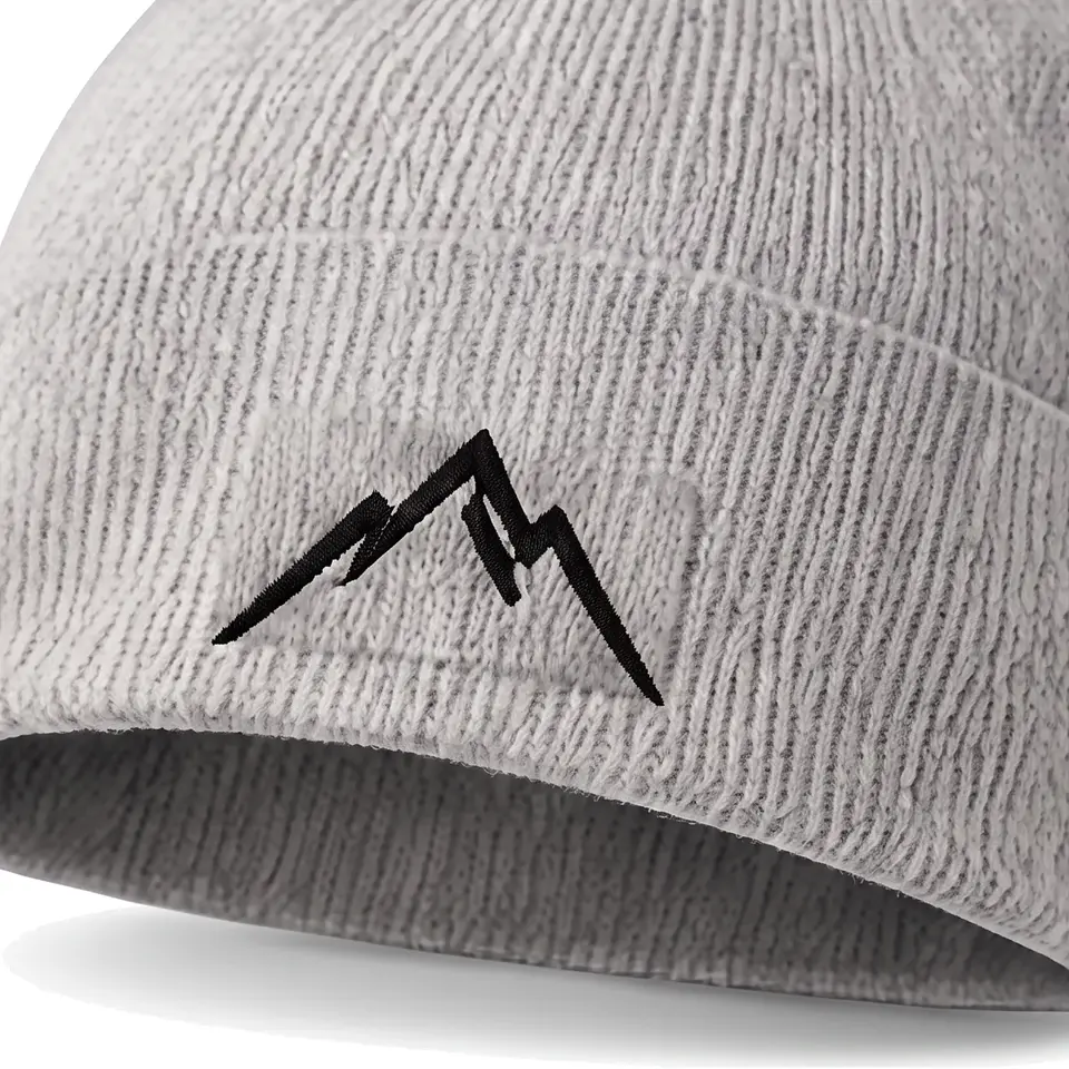 Col Rib beanie in Light Grey: close-up of the cuff embroidery