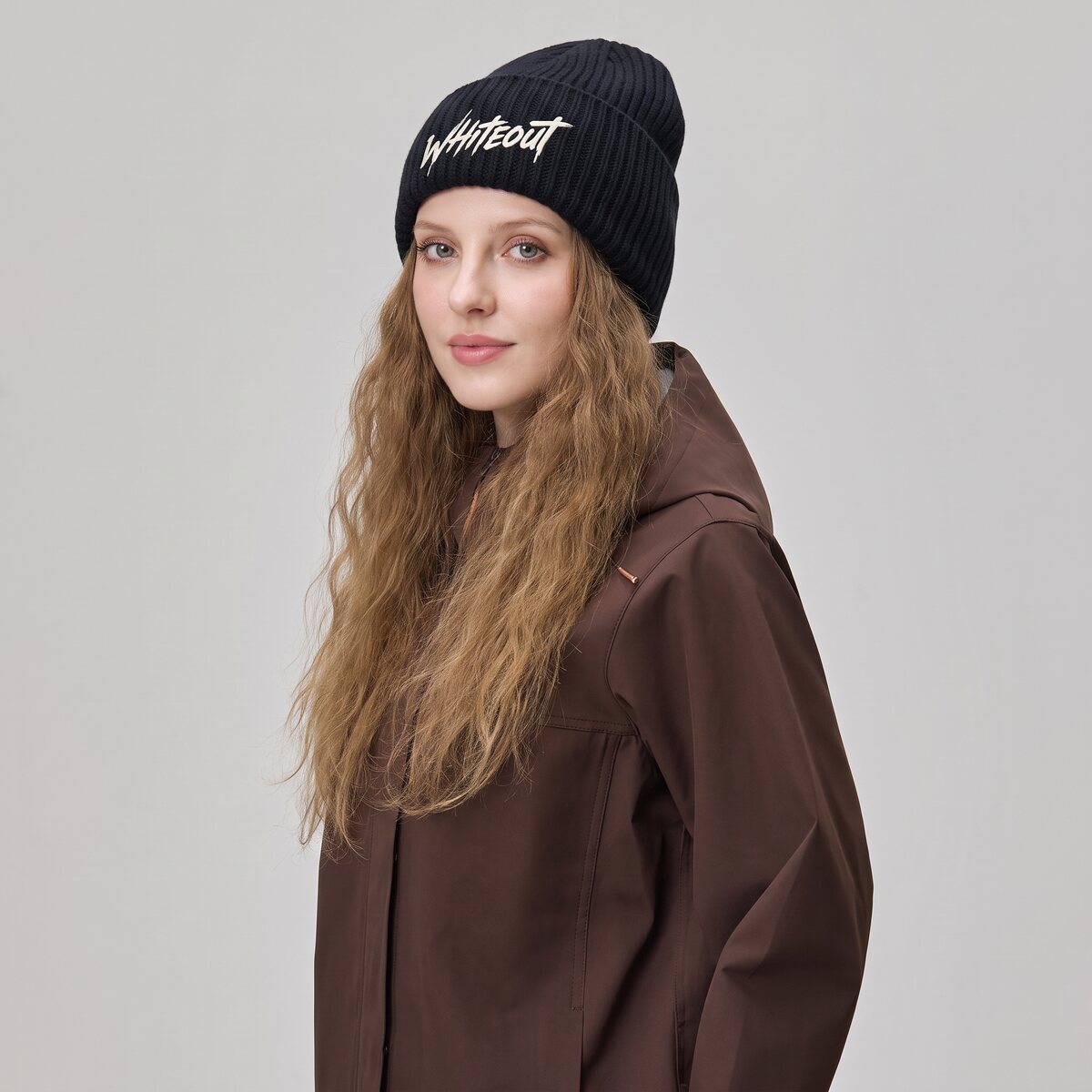 Model in a black ribbed beanie with the Whiteout script logo embroidered on the cuff