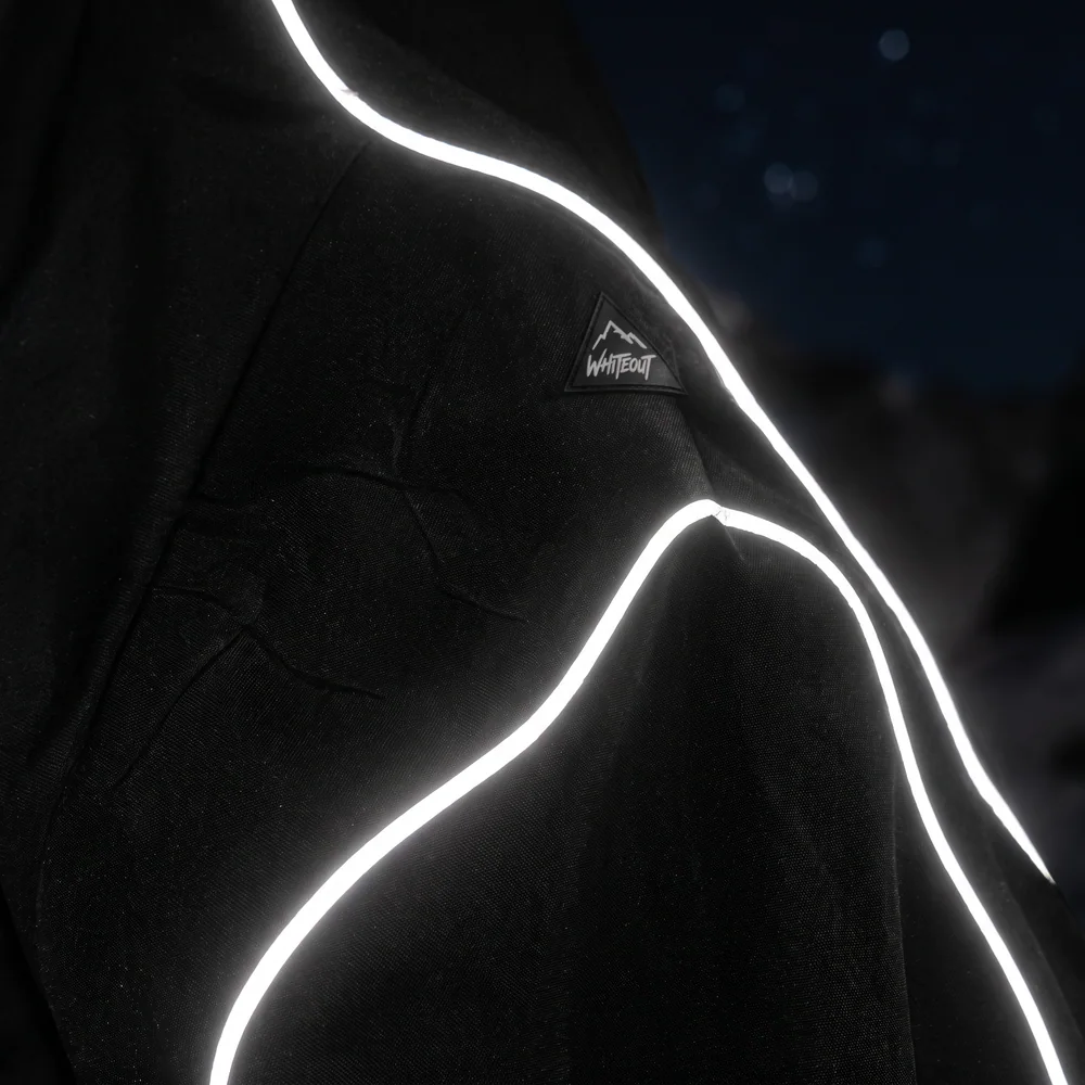 Bright reflective-style piping curving across black fabric at night