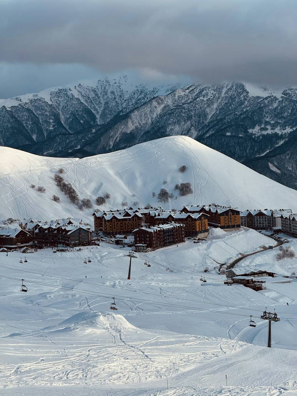 Snowy mountain village with ski lifts